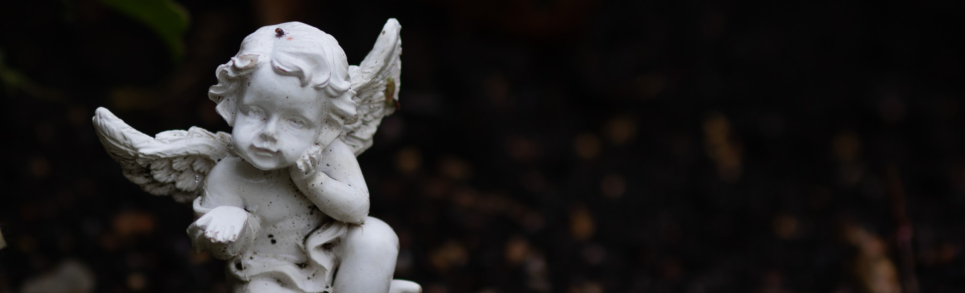 Engelsfigur vor dunklem Hintergrund