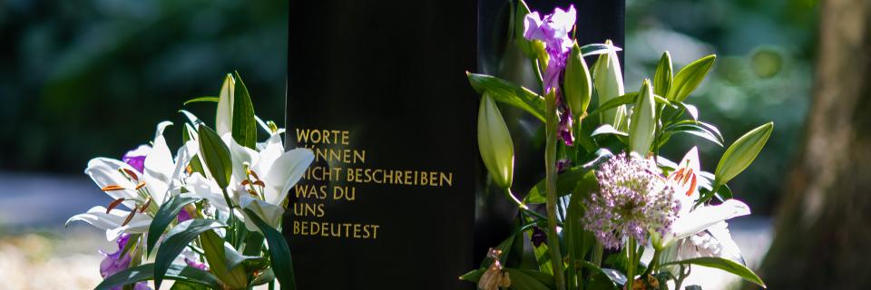 Symbolbild: Grabstein mit Blumen